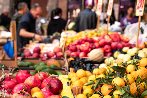 Fototapeta Naklejka Na Ścianę i Meble -  Fruit and vegetable stall in a street market in Naples in Italy. Signs with prices in the background, oranges, bananas, pomegranates.