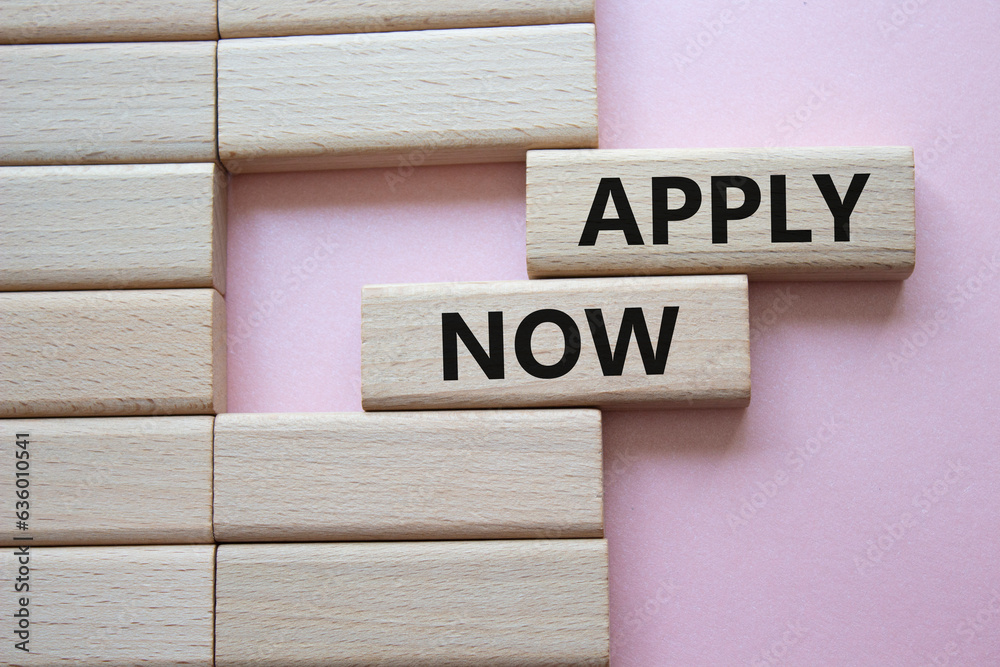 Apply now symbol. Concept word Apply now on wooden blocks. Beautiful pink background. Business and Apply now concept. Copy space Apply now symbol. Concept word Apply now on wooden blocks. Beautiful pink background. Business and Apply now concept. Copy space
