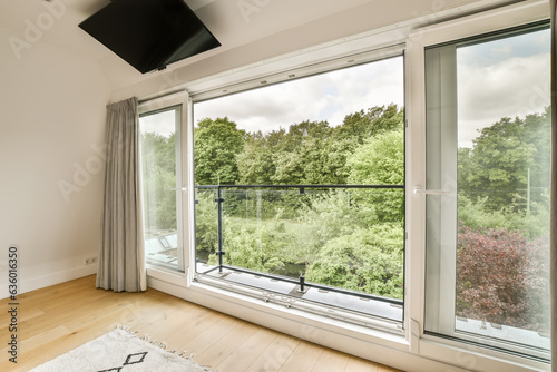 Bild auf Leinwand a bedroom with a large window looking out at the trees outside and an area rug o