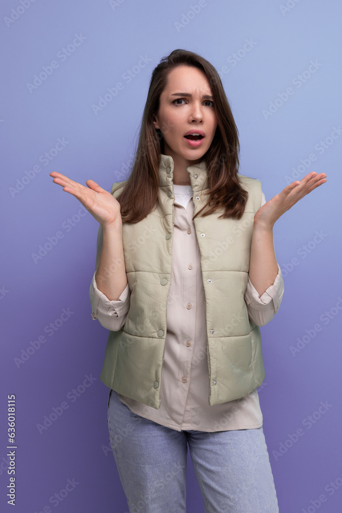 upset concentrated brunette young woman in vest and shirt in studio upset concentrated brunette young woman in vest and shirt in studio