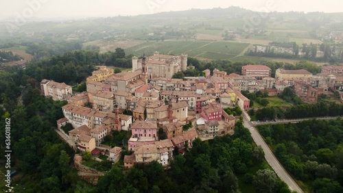 Drone view of Costigliole d'Asti village with vegetation in Province of Asti, Italy with misty sky photo