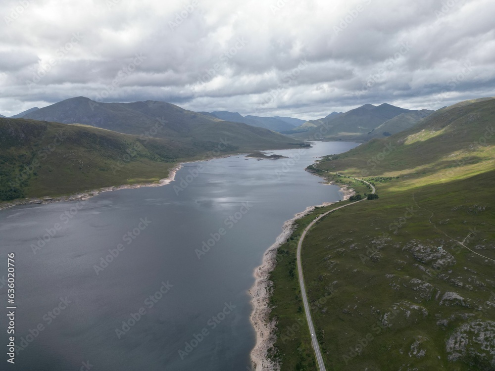 Aerial view of Loch Cluanie in the Highlands of Scotland, surrounded by verdant green hills