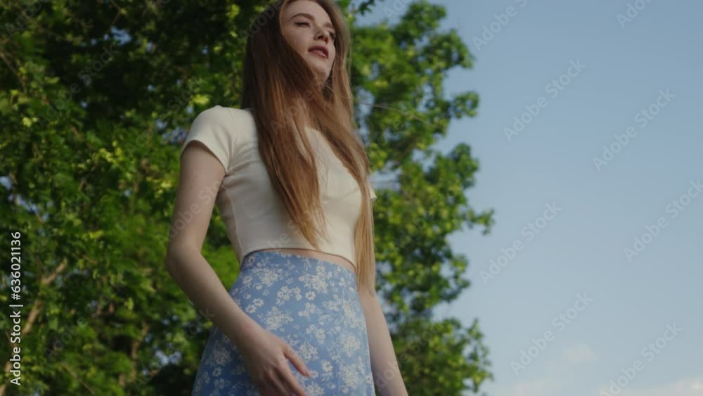Red haired beautiful young woman, standing in green summer park, posing. Success, freedom and happiness concept Red haired beautiful young woman, standing in green summer park, posing. Success, freedom and happiness concept