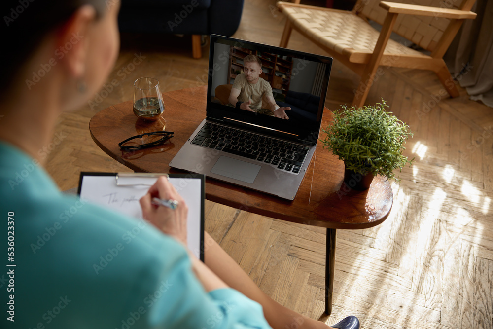 Woman psychologist consulting soldier online holding virtual therapy on laptop