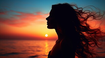 Young woman s silhouette against a sunset over the sea