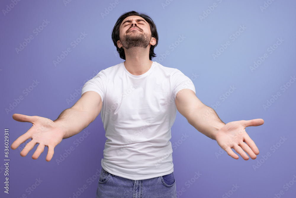 dreamy young brutal brunette man in a white t-shirt and jeans stretches out his arms for a hug dreamy young brutal brunette man in a white t-shirt and jeans stretches out his arms for a hug