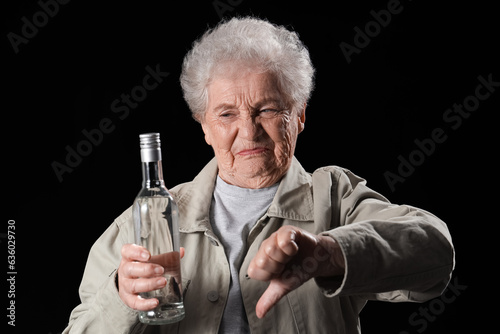 Senior woman with bottle of...