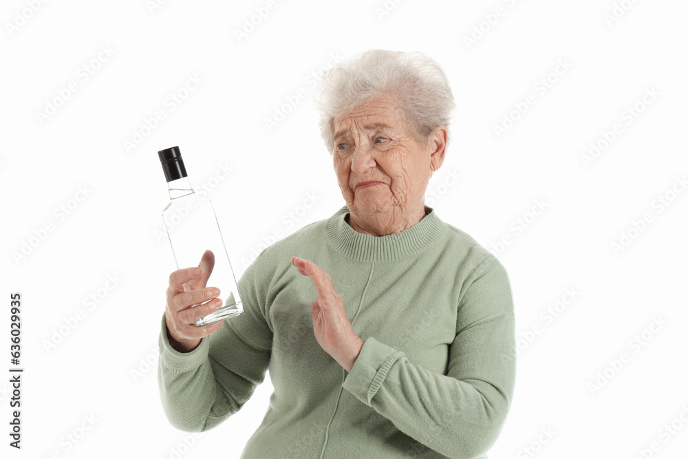 Senior woman rejecting bottle of vodka on white background Senior woman rejecting bottle of vodka on white background
