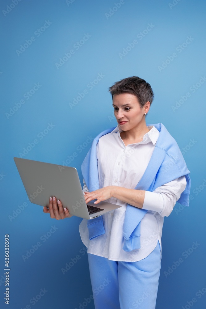 european young brunette woman with tousled hair works remotely using laptop european young brunette woman with tousled hair works remotely using laptop