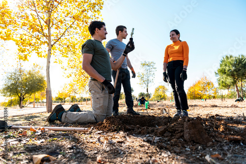 Volunteers group in cooperative teamwork planting trees  photo