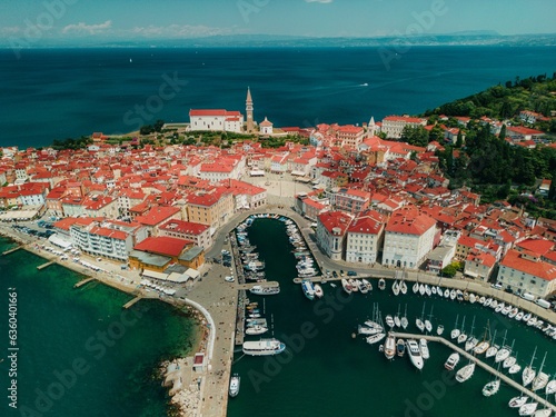 Scenic view of a small island with a plethora of boats surrounding it in Piran, Slovenia photo