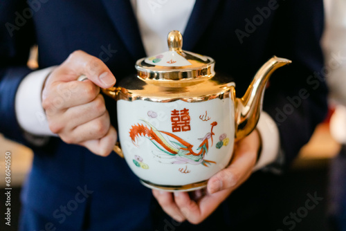 Closeup of Man in Suit Holding Tea Pot photo