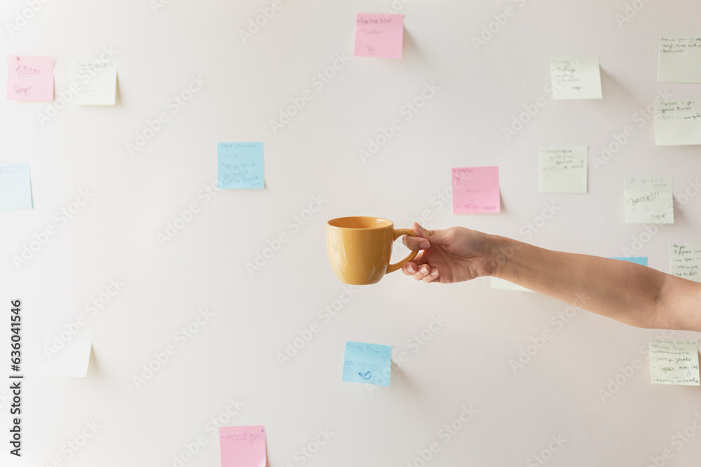 hand with a mug on the background of the wall hand with a mug on the background of the wall
