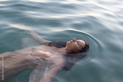 mental health, portrait of sad calm woman floating in water, apathy