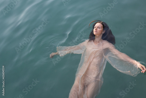 woman floating in water, mental health, apathy and sadness