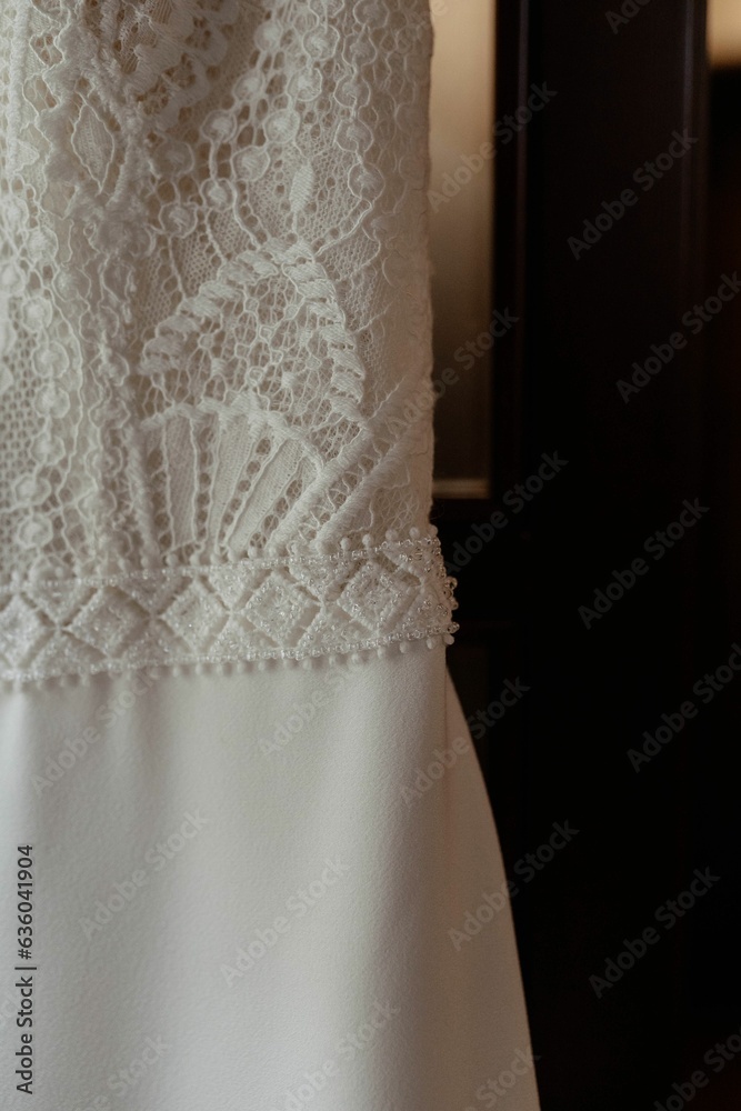 a close up view of a wedding dress hanging on a door a close up view of a wedding dress hanging on a door