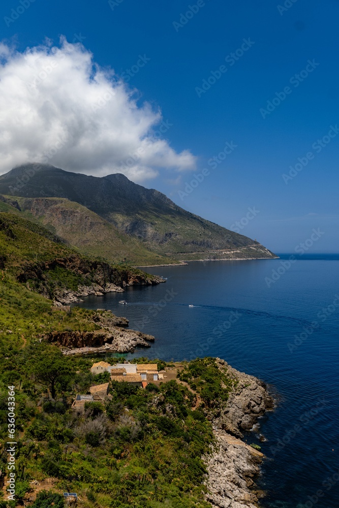 a hillside next to the sea with a house in it