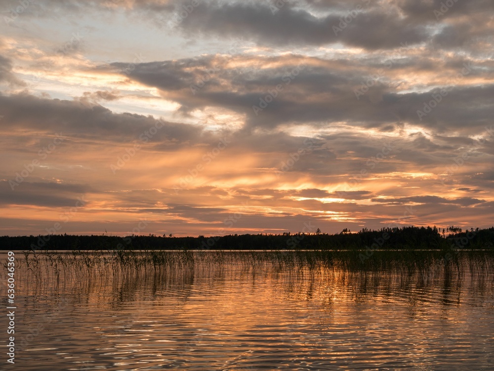 Fototapeta premium Closeup of a beautiful and vibrant sunset above a tranquil body of water