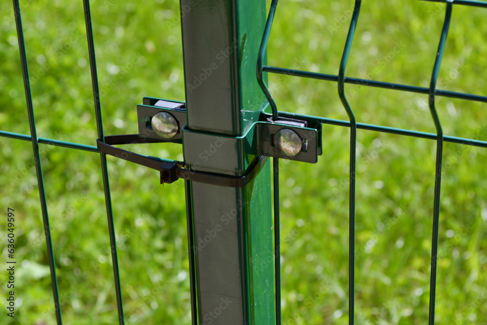 Obraz premium Metal mesh fence attached by plastic strap of clip