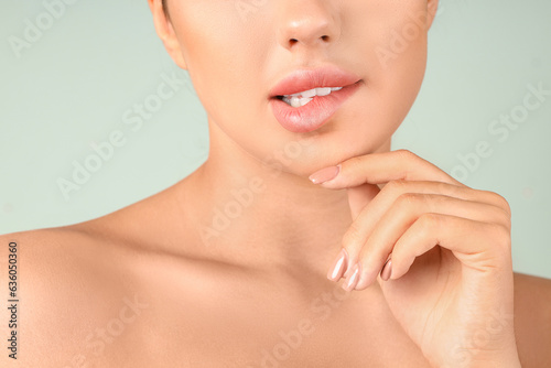 Thoughtful young woman with beautiful lips on green background  closeup