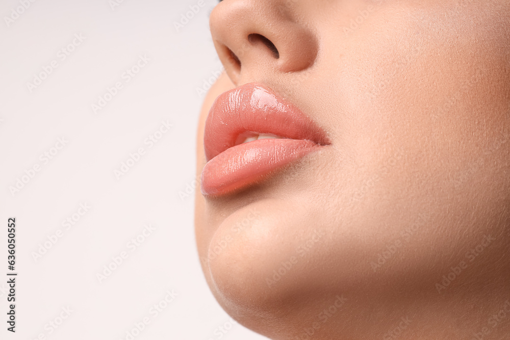 Young woman with beautiful lips on light background, closeup Young woman with beautiful lips on light background, closeup
