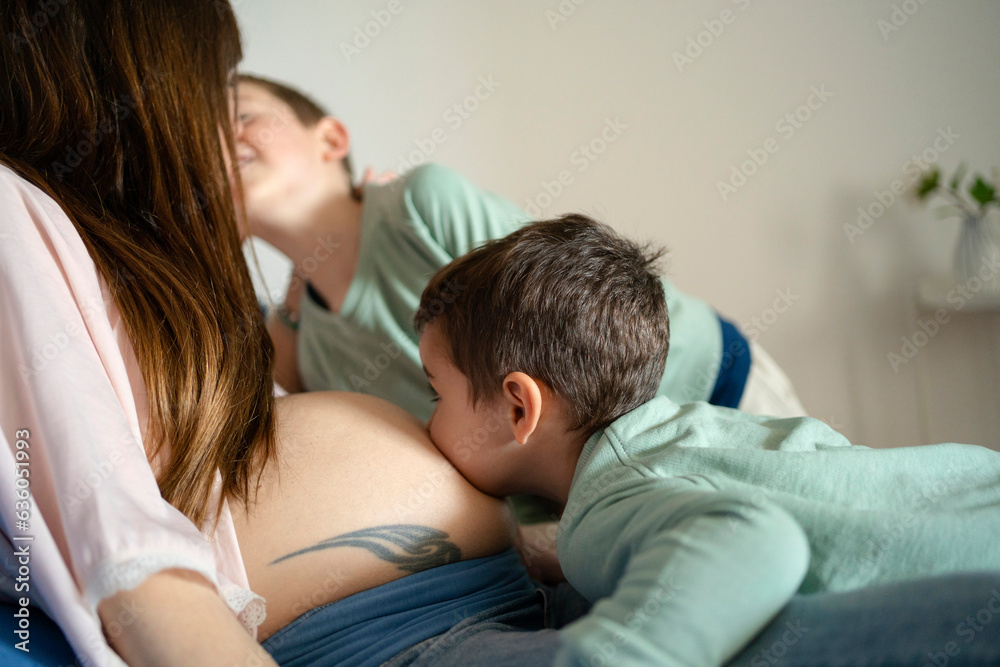 Kid kissing his mother's pregnant belly Kid kissing his mother's pregnant belly