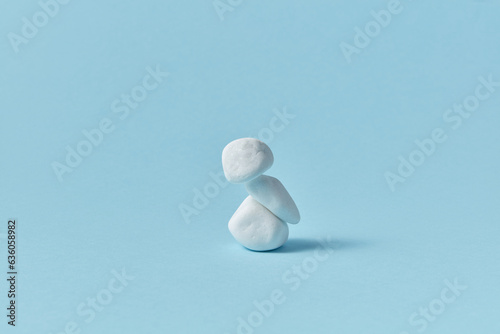 White pebble stone pyramid on blue background.