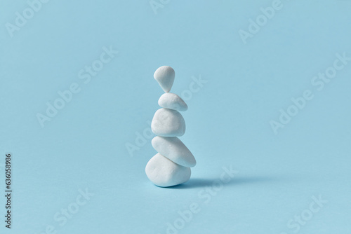 White sea pebble stone stack on light blue background. photo