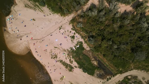 Many people sunbathing on sandy beach and swimming in Vistula River close to the Anna Jagiellon Bridge, Warsaw. A small amount of water in the river. Water shortage. Unguarded beach. 4K 59.94 fps photo