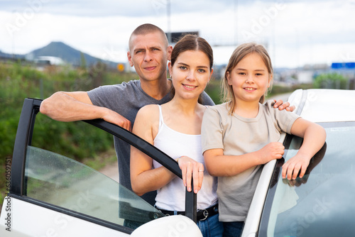 Happy family posing near new car outdoor photo