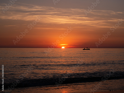 Sunset in Italy Toskana at mittelmeer with fishing boat in the water and small Waves Dawn