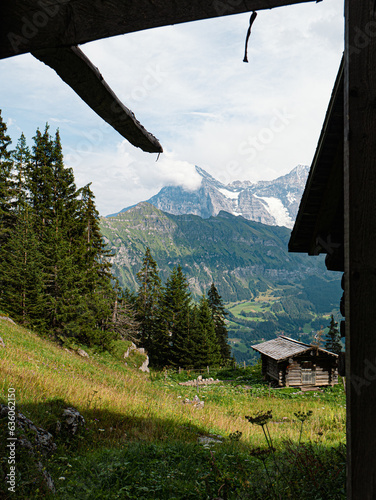 Wood cabin with a beautiful view at the Eiger North Face in switzerland berner oberland  with massive glaciers and a wooden cabin photo