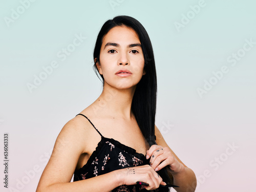 Serious woman brushing her hair tips photo