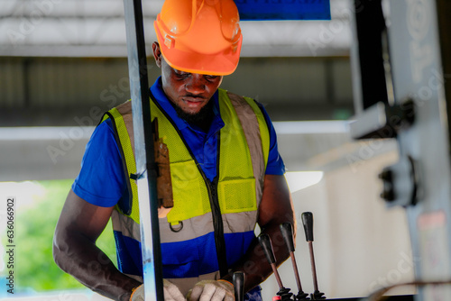 Factory engineer African man checking and reparing mahine at heavy factory.Worker works at heavy machine at industry factory. with machinery equipment plant technology. photo