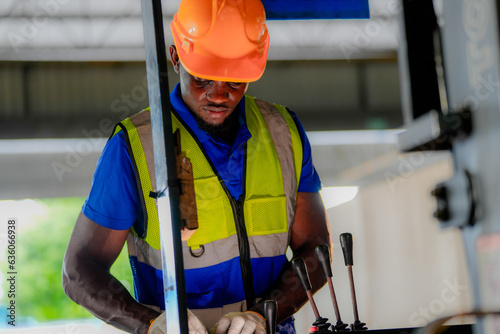 Factory engineer African man checking and reparing mahine at heavy factory.Worker works at heavy machine at industry factory. with machinery equipment plant technology. photo