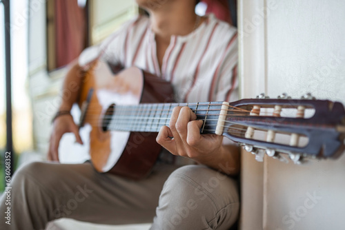 teenage boy playing his guitar in a caravan