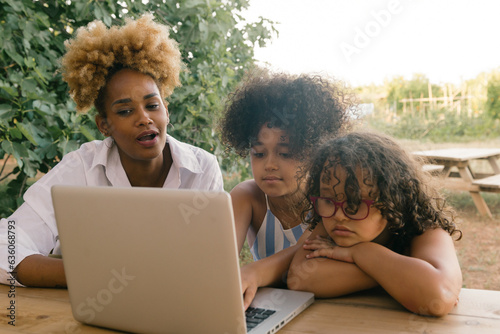 Mother with her two daughters using the computer