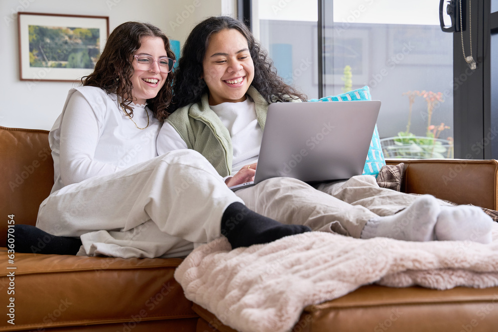 Young lesbian couple at home using laptop together Young lesbian couple at home using laptop together