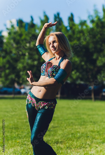 Street shaabi dance and urban dancer concept - Cheerful belly dancer dancing with arabic music on the street. photo