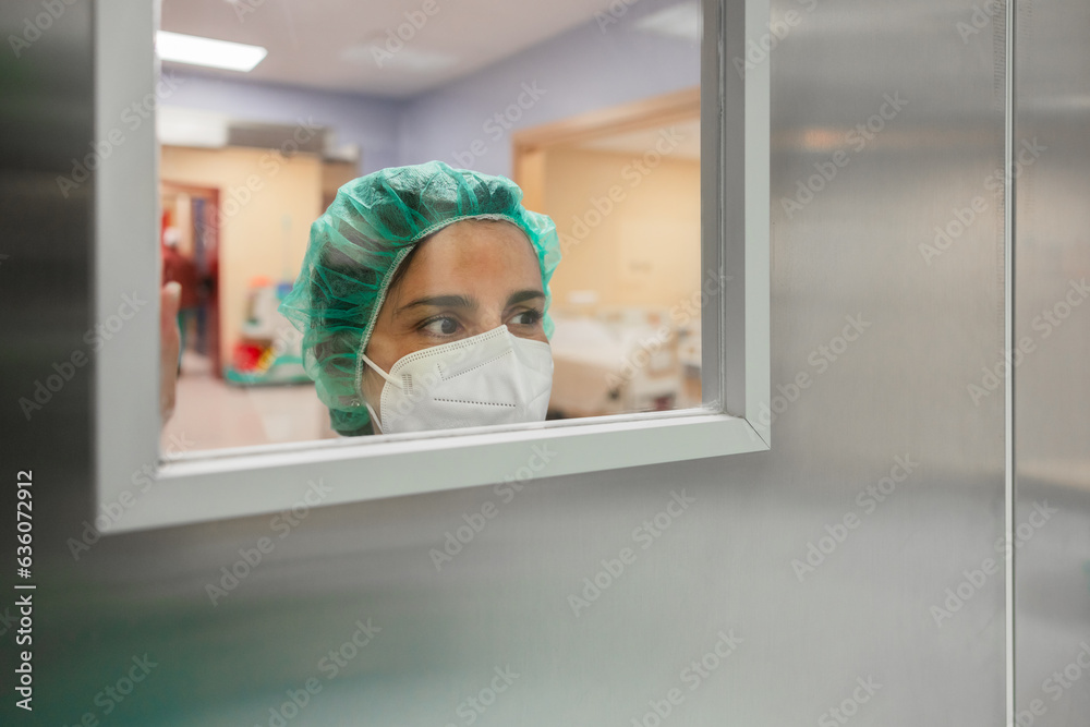 Nurse looking through window of operating room door Stock Photo | Adobe ...