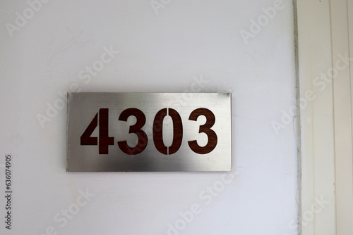 hotel room number 4303 is taped to the wall of the hotel hallway