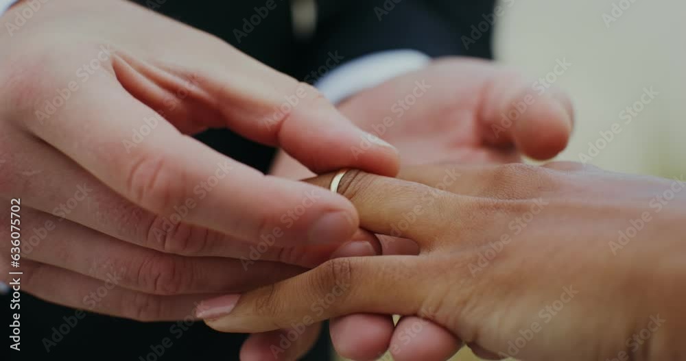 The groom puts a ring on the bride's finger, standing outdoor, close-up of hands The groom puts a ring on the bride's finger, standing outdoor, close-up of hands