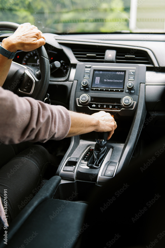 middle aged woman in car putting the vehicle into gear to drive middle aged woman in car putting the vehicle into gear to drive