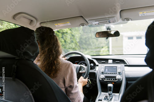 middle aged woman inside a car getting ready to drive somewhere