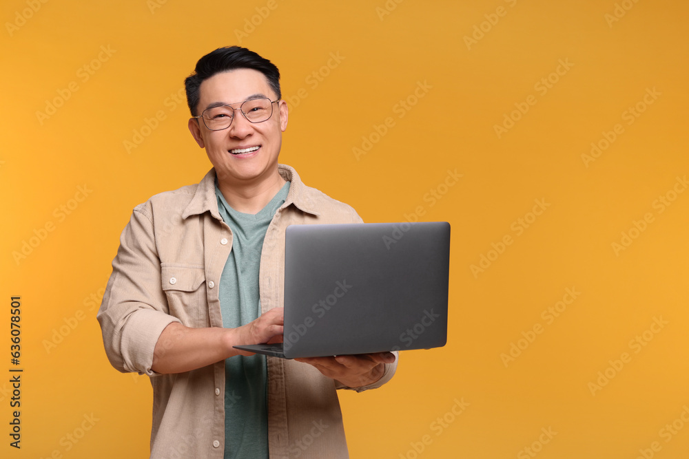 Happy man with laptop on yellow background, space for text Happy man with laptop on yellow background, space for text