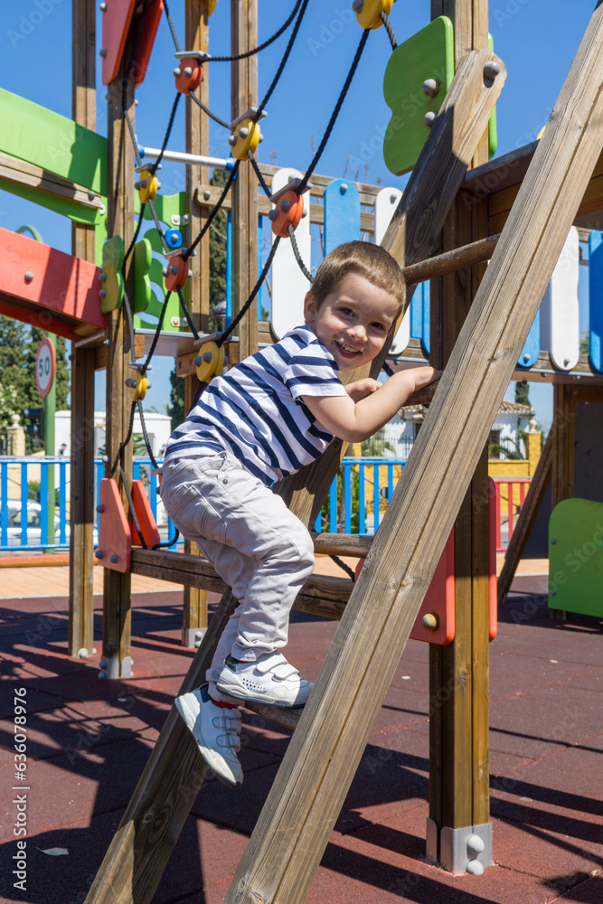 Boy climbing a wooden ladder in a playground Boy climbing a wooden ladder in a playground