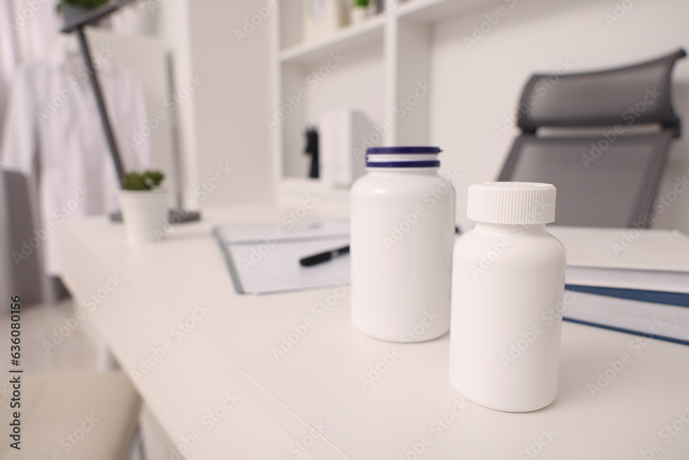 Plastic medical bottles on white table, space for text. Doctor's workplace Plastic medical bottles on white table, space for text. Doctor's workplace