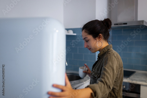 teen girl looking inside the fridge at home photo