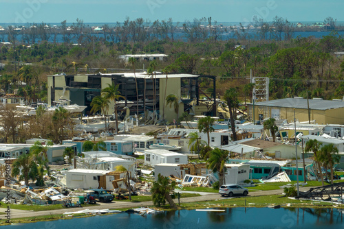 Hurricane destroyed suburban houses roofs in Florida mobile home residential area. Consequences of natural disaster