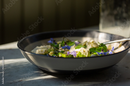 spring vegetable salad with pasta and edible flowers.  photo